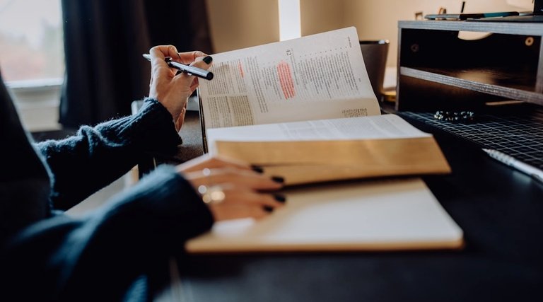 Profissional analisa documentos e certidões imobiliárias com marcações coloridas em mesa de escritório