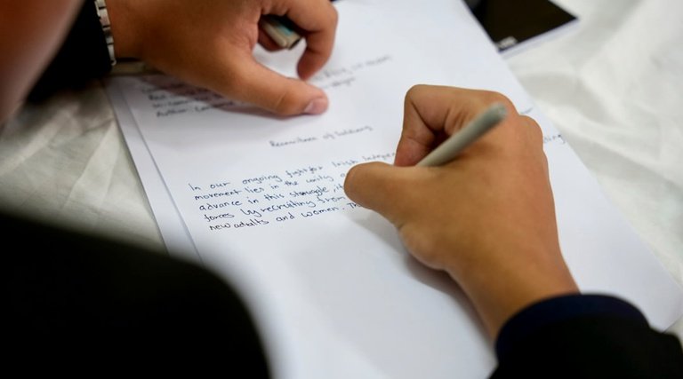 Pessoa revisa documento com caneta identificando cláusulas ausentes em contrato de compra e venda de imóvel
