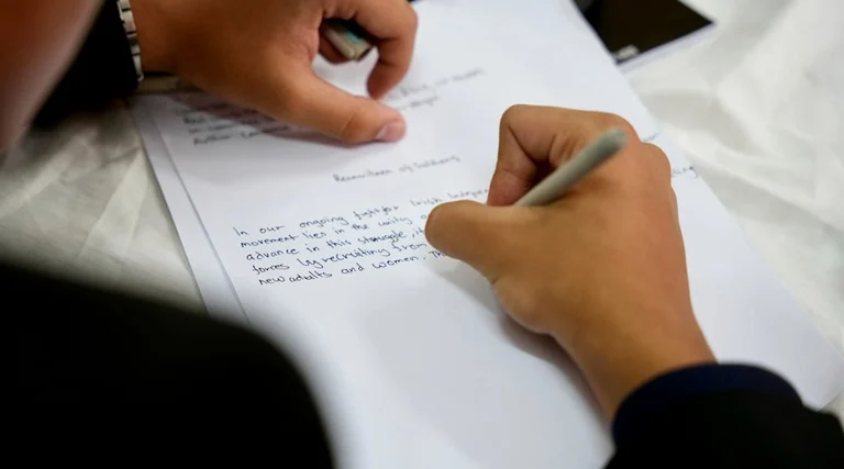 Pessoa revisa documento com caneta identificando cláusulas ausentes em contrato de compra e venda de imóvel