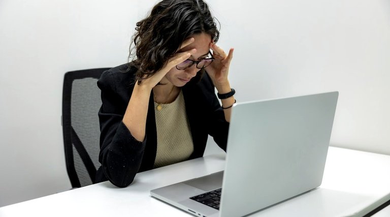 Profissional preocupada diante do notebook após negativa de financiamento imobiliário