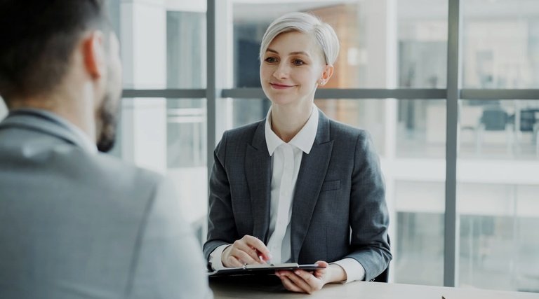 Advogado para imóvel de luxo em reunião profissional Advogado para imóvel de luxo: profissional de terno segurando tablet em conversa com cliente em ambiente corporativo