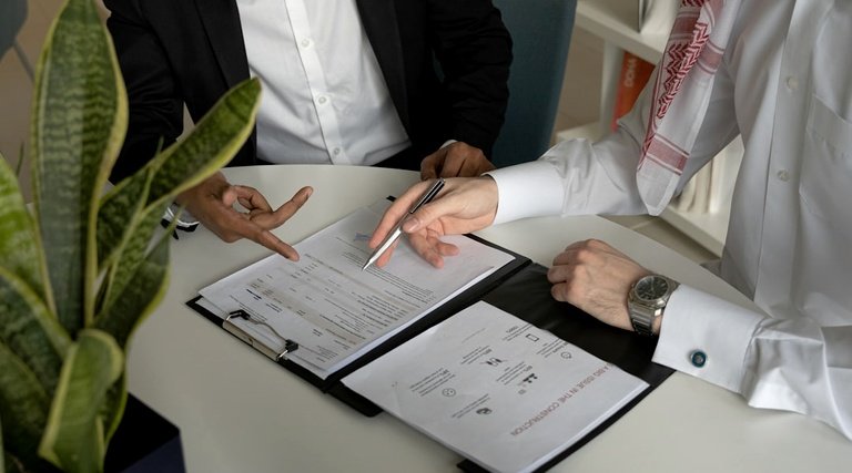 Atraso entrega apartamento análise documentos Atraso na entrega de apartamento: duas pessoas analisando documentos em pranchetas sobre mesa