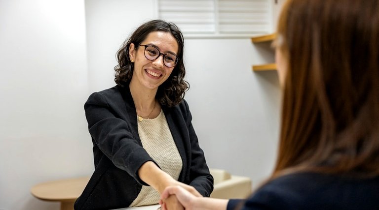 Advogado holding familiar: profissional de blazer preto cumprimentando cliente em ambiente corporativo