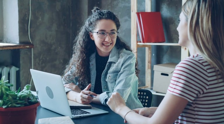 Advogado holding familiar: três mulheres conversando em sofá, uma com notebook, outra com tablet e terceira gesticulando