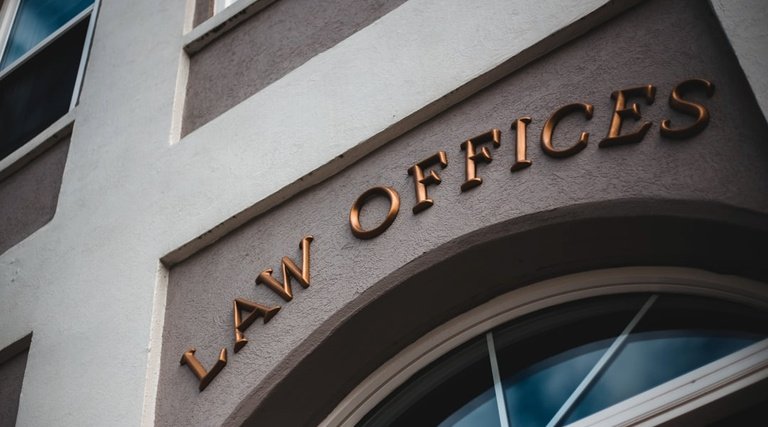 Fachada Law Offices herança imposto de renda Quem recebeu herança precisa declarar imposto de renda: fachada de edifício com letreiro Law Offices em metal dourado