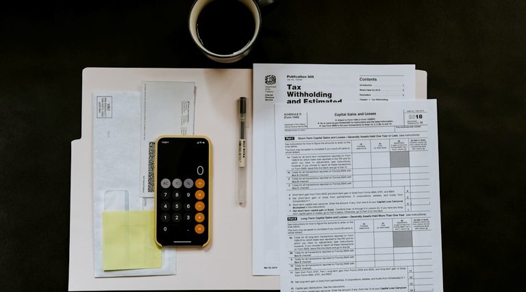 Declaração de herança e documentos fiscais Quem recebeu herança precisa declarar imposto de renda: calculadora sobre formulários fiscais e documentos em mesa