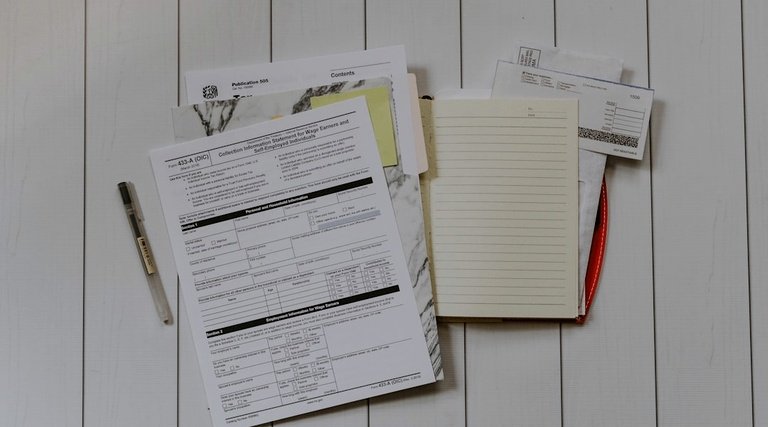 Documentos para declaração de herança e imposto Quem recebeu herança precisa declarar imposto de renda: formulários e documentos sobre mesa com bloco de anotações e caneta