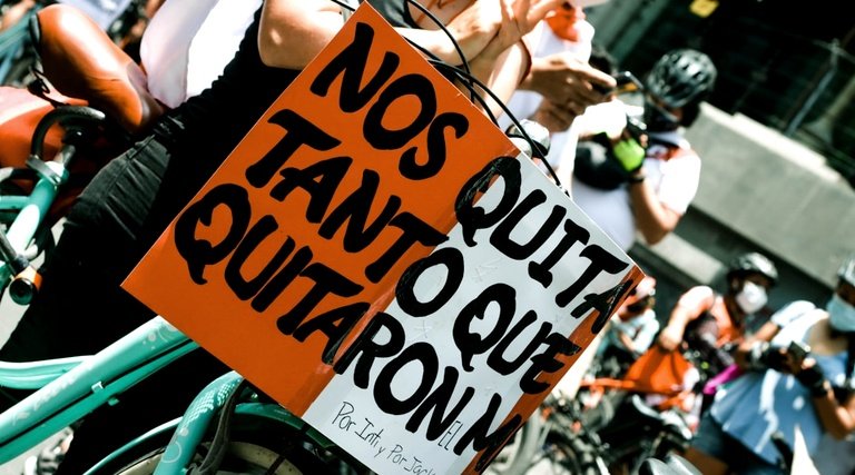 imóvel quitado e não entregue: Proprietários segurando cartaz laranja reivindicando entrega de imóvel quitado