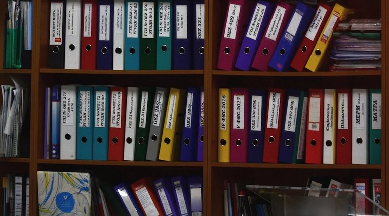 imóvel quitado e não entregue: Pastas organizadas em prateleira de escritório jurídico com documentos de processos judiciais
