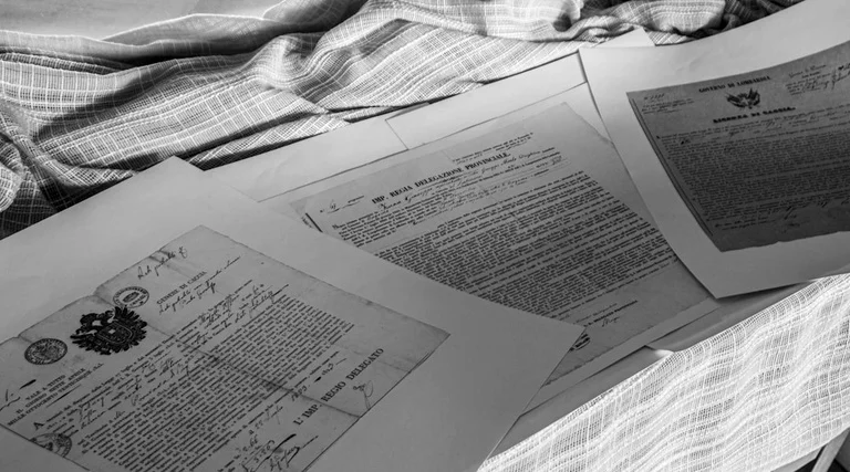 Imposto de herança: análise de documentos sobre doação imposto de herança: Mãos revisam documentos oficiais sobre doação de imóvel e planejamento sucessório familiar