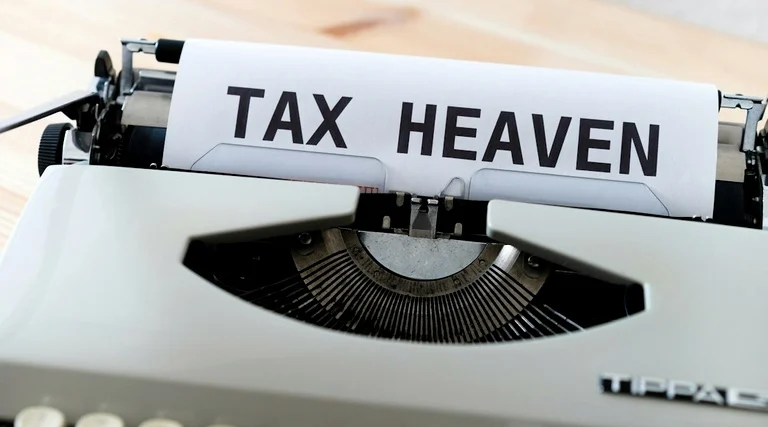 holding patrimonial vantagens e desvantagens: Máquina de escrever exibe texto TAX HEAVEN representando estratégias